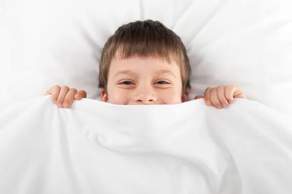 Fröhlicher Junge im Bett — Stockfoto