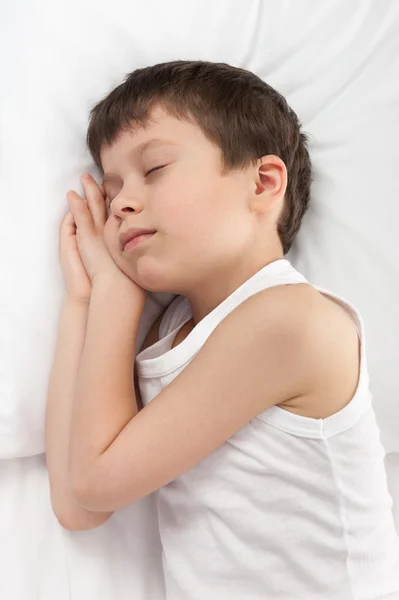 Fröhlicher Junge schläft im Bett — Stockfoto