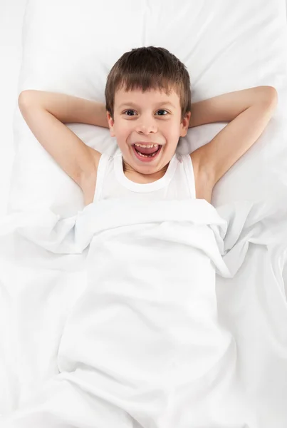 Fröhlicher Junge im Bett — Stockfoto