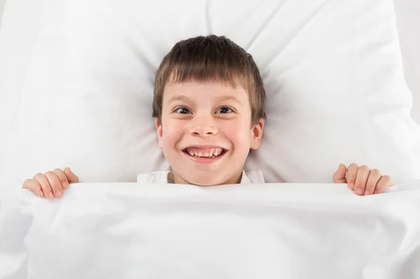 Fröhlicher Junge im Bett — Stockfoto