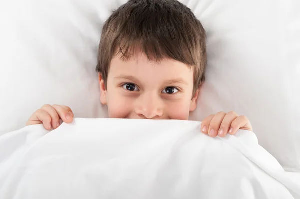 Fröhlicher Junge im Bett — Stockfoto