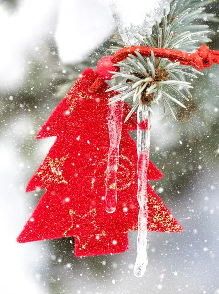 Julgran leksak i snöfall med istapp — Stockfoto