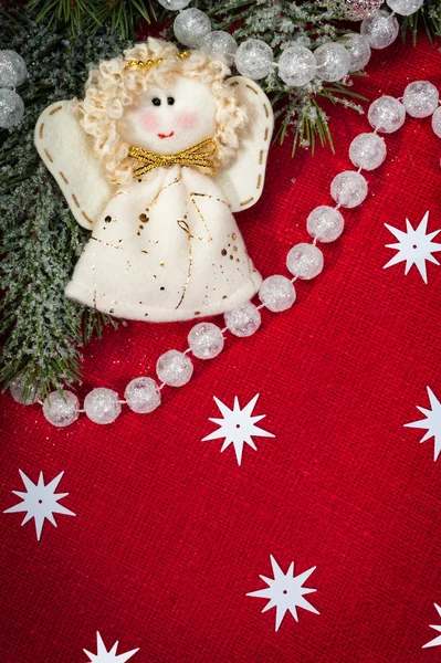 Christmas decoration and angel toy on red textile — Stock Photo, Image