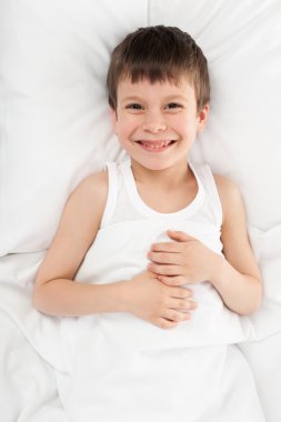 cheerful boy in white bed