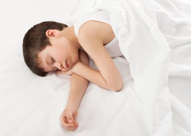 cheerful boy in white bed