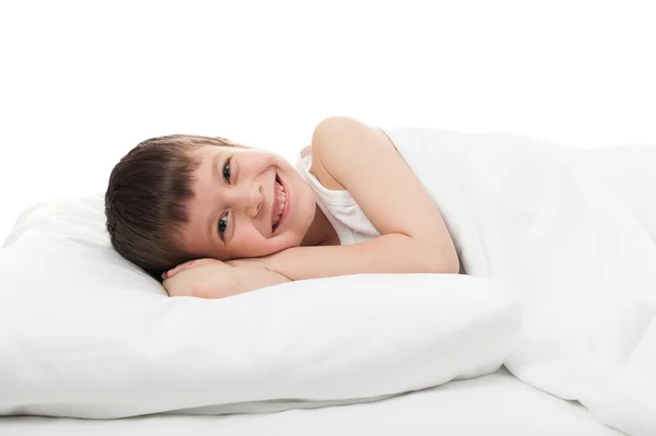 Cheerful boy in white bed — Stok fotoğraf