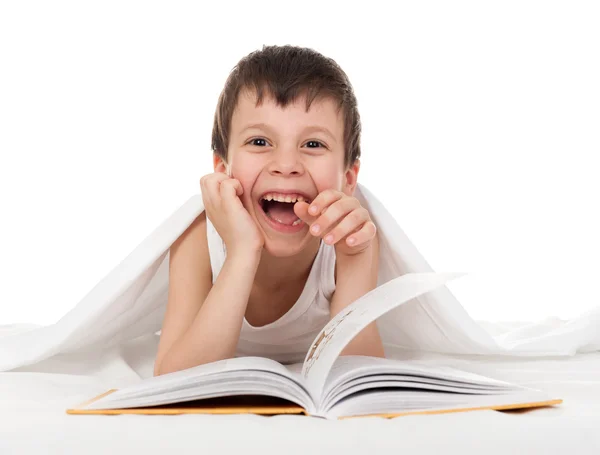 Chico leer un libro en la cama — Foto de Stock