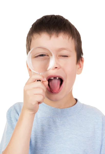 Boy looks through a magnifying glass — Stock Photo, Image
