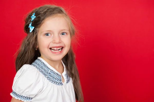 Smiling girl portrait on red — Stock Photo, Image