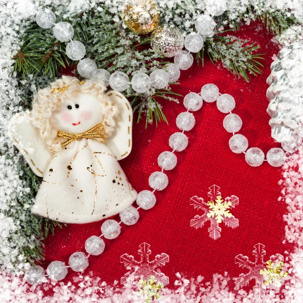 Weihnachtsdeko und Engelsspielzeug auf rotem Textil — Stockfoto