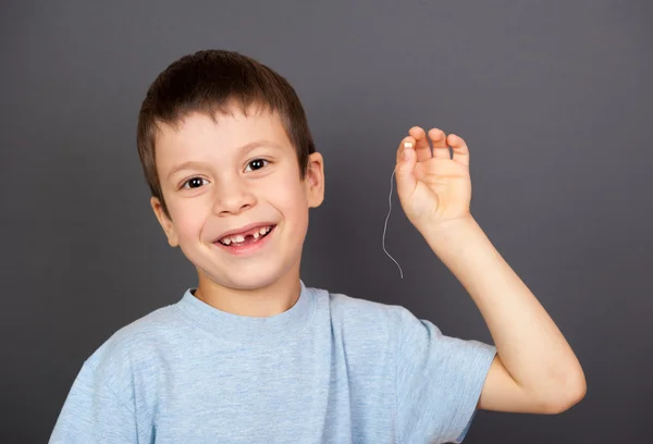 Αγόρι δείχνουν χαμένο δόντι σε ένα νήμα — Φωτογραφία Αρχείου