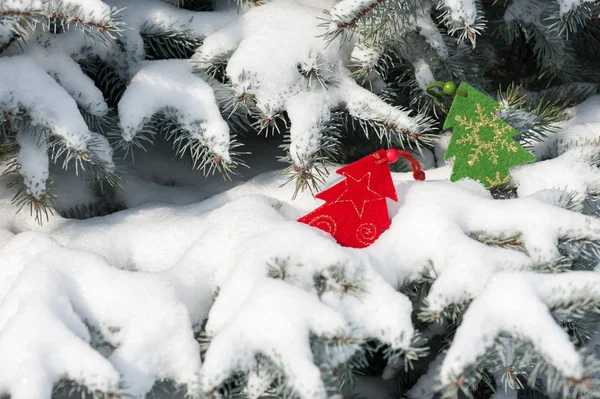 Vánoční hračky červený strom v sněhu na jedle — Stock fotografie