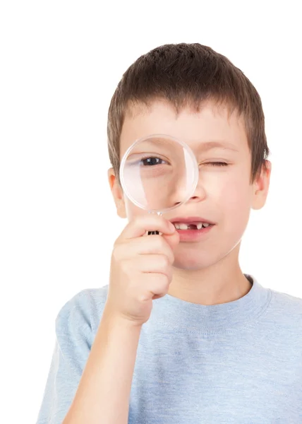 Boy looks through a magnifying glass — Stock Photo, Image