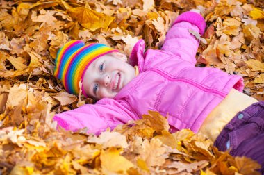 kız sarı yapraklar sonbaharda parkta yatıyor