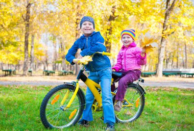 Çocuk sonbahar parkta bisikletle