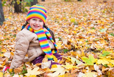 kız sarı yapraklar sonbaharda parkta oturmak