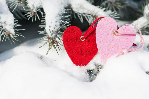 Rote Herzen Spielzeug im Schneefall auf Tanne — Stockfoto