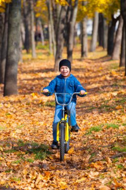 çocuk parkında bir bisiklet ile gidiyor
