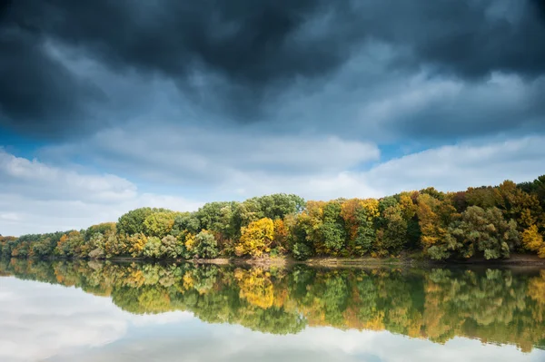 Schöner Fluss und Wald mit dunklem Himmel im Herbst — Stockfoto