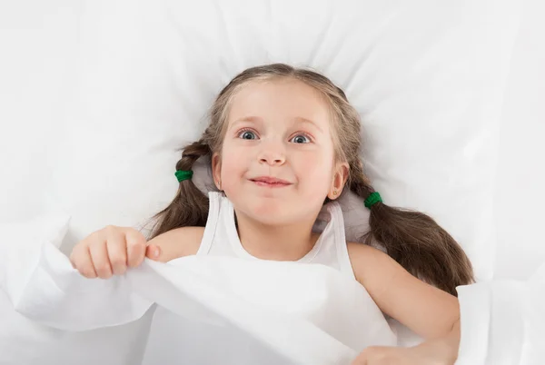 Fröhliches Mädchen im weißen Bett — Stockfoto