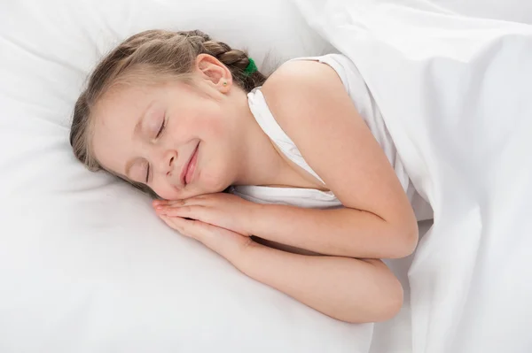 Glad tjej sova i vit säng — Stockfoto