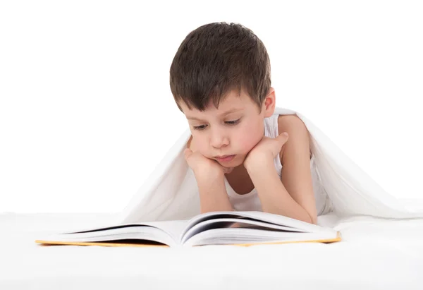 Chico leer un libro en la cama — Foto de Stock