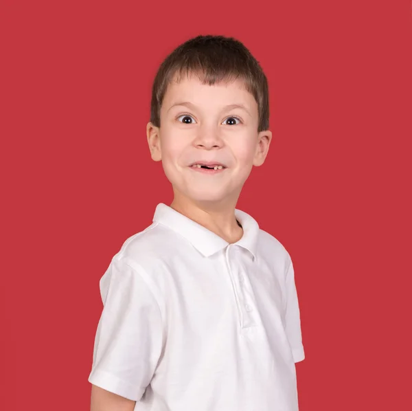 Pojke stående i vit skjorta på röd — Stockfoto