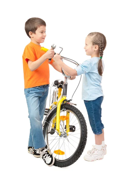 Chłopiec i dziewczynka naprawy roweru na białym tle — Zdjęcie stockowe