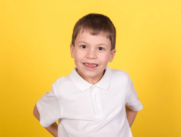 Pojke stående i vit skjorta på gula — Stockfoto