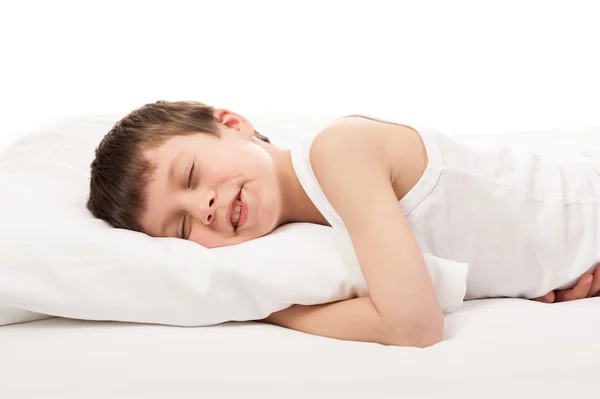 Веселый мальчик в белой кровати — стоковое фото