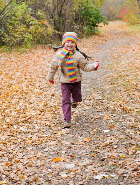 女孩跑在片秋色的公园 — 图库照片