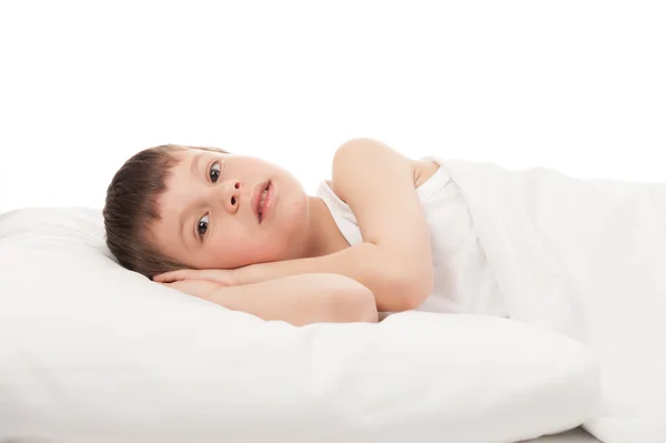 Menino na cama branca — Fotografia de Stock