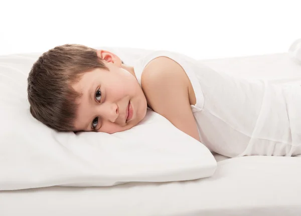 Boy v bílé posteli — Stock fotografie