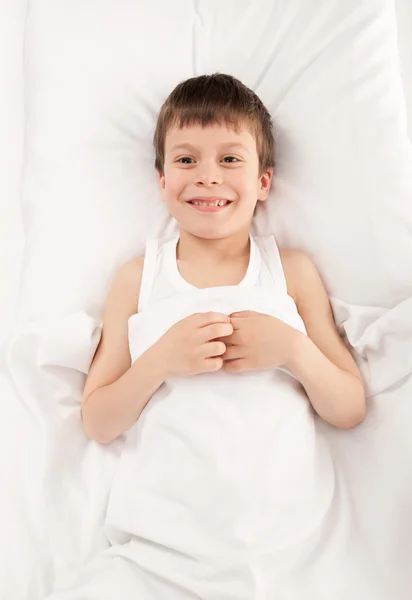 Niño en cama blanca — Foto de Stock