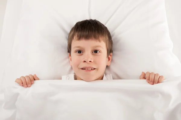 Junge im weißen Bett — Stockfoto