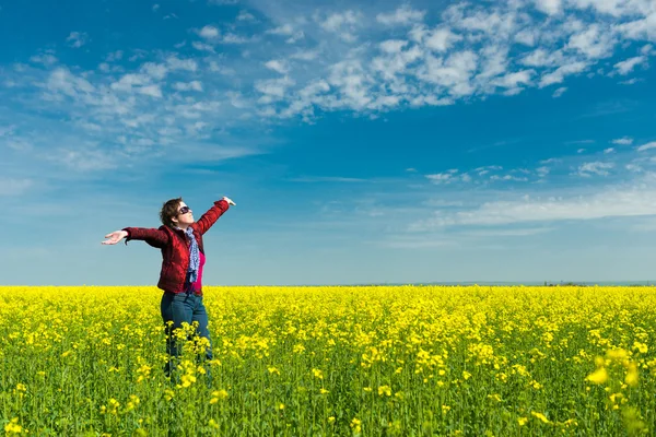 Vrouw in geel veld van verkrachting — Stockfoto