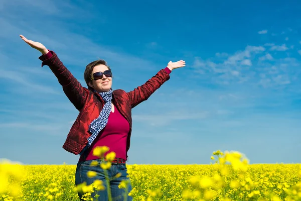 Vrouw in geel veld van koolzaad — Stockfoto