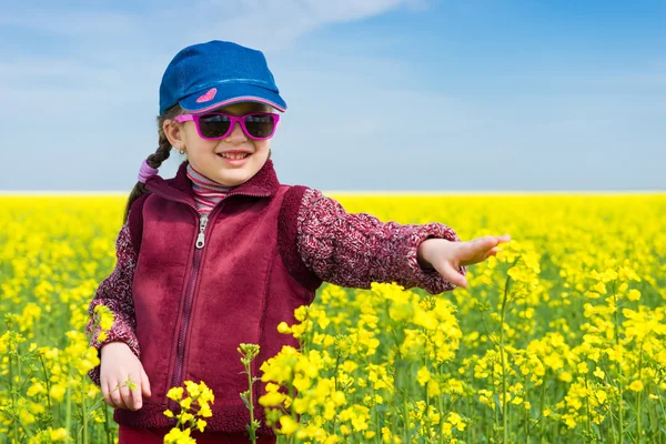 Meisje in geel veld van verkrachting — Stockfoto