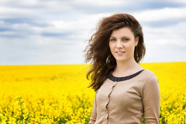 Retrato de mujer en campo de flores amarillo —  Fotos de Stock
