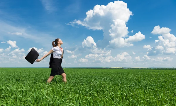 Девушка с портфелем ходит по траве — стоковое фото