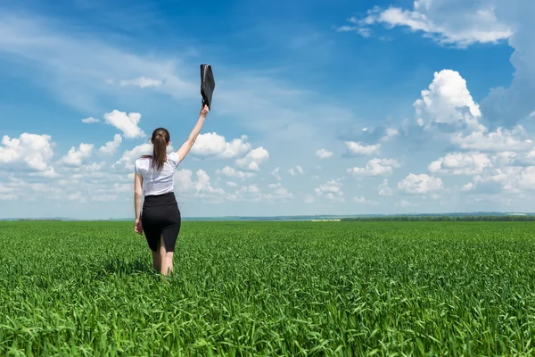 Menina com uma pasta andando na grama — Fotografia de Stock