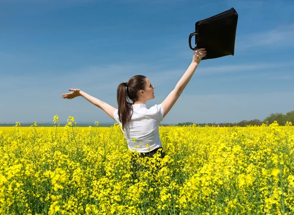 Mädchen mit Aktentasche auf gelbem Blumenfeld — Stockfoto