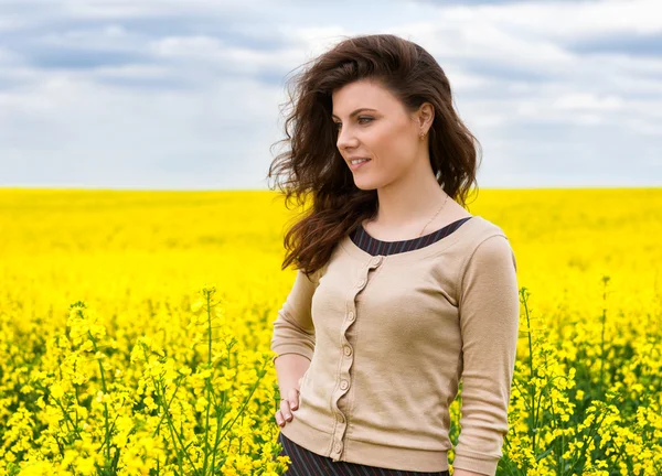Ritratto donna nel campo di fiori gialli — Foto Stock