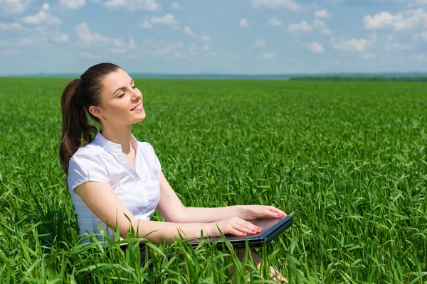Business girl relaxing on field — Stock Photo, Image