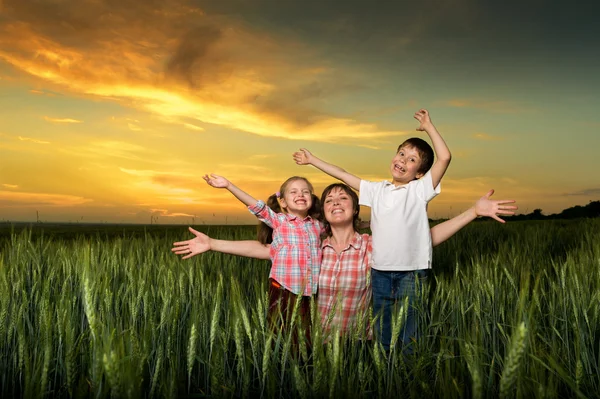 Família feliz ao pôr do sol — Fotografia de Stock