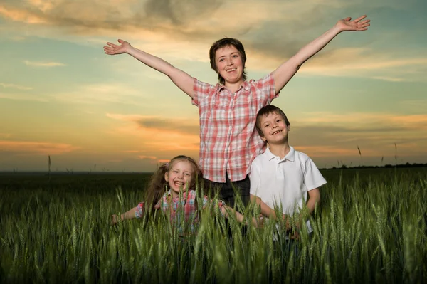 Família feliz ao pôr do sol — Fotografia de Stock