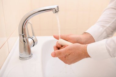 Yıkanırken sabun ya da jöle, lavaboda akan su, temizlik ve hijyen, beyaz gömlek giymiş erkek elleri.