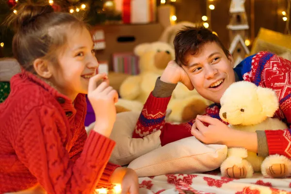 男孩和女孩在新年或圣诞节装饰肖像画 他们撒谎 吃糖果和饼干 节日灯饰 礼物和装饰玩具的圣诞树 — 图库照片