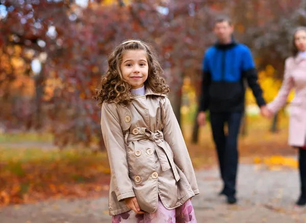 Portret Van Een Meisje Een Herfstpark Zijn Ouders Achter Haar — Stockfoto