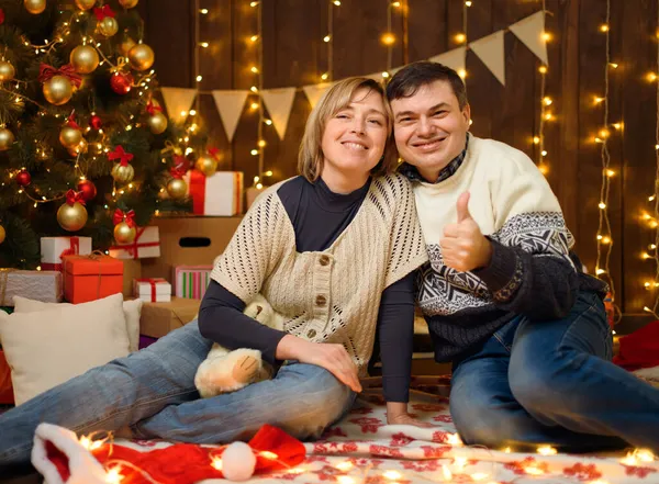一对夫妇在新年装饰中的肖像 他们摆姿势 玩得很开心 节日彩灯 礼物和装饰有玩具的圣诞树 — 图库照片